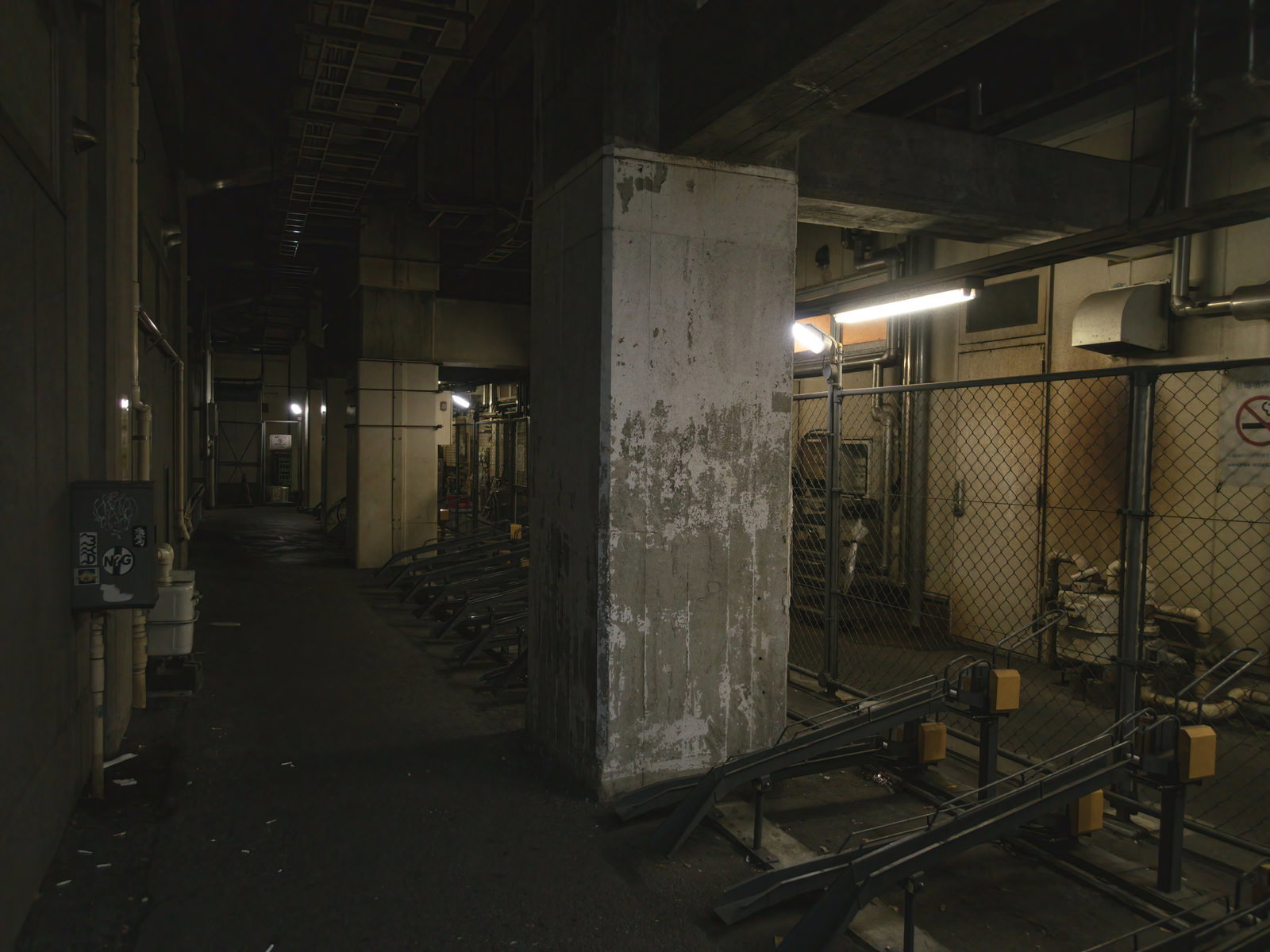 夜間照明に照らされた高架下の機械式駐輪場