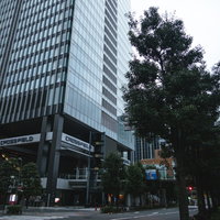 秋葉原に立ち上がる高層ビルと緑の街路樹の都市風景の写真