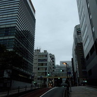 車道と歩道沿いのビル群の写真