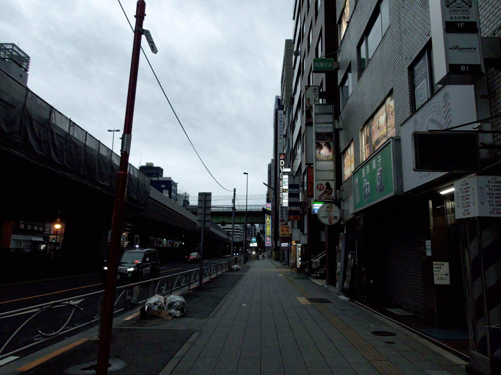 秋葉原の歩道脇に置かれたごみ袋と周囲の建物や袖看板