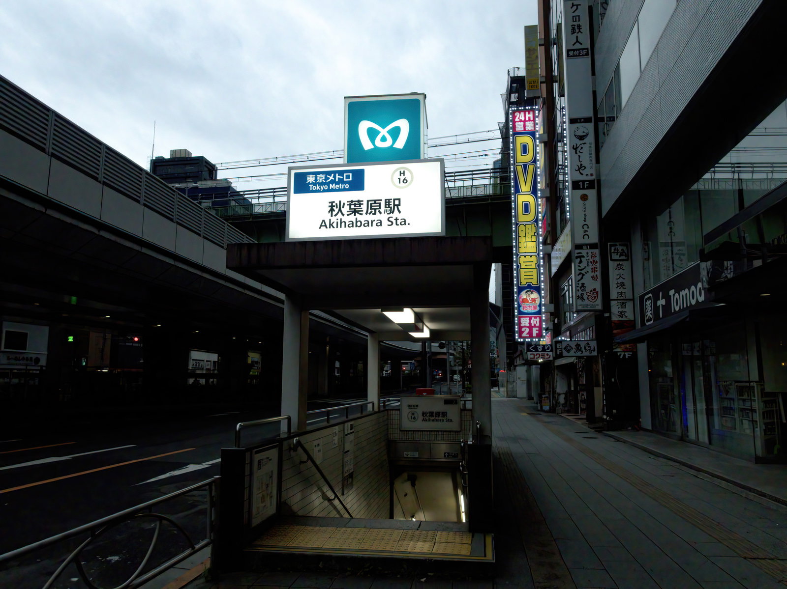 東京メトロ秋葉原駅の地下入口と周辺の看板が見える夕暮れの駅前風景