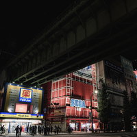 秋葉原ガード下の夜間風景、赤い看板とビルが立ち並ぶの写真