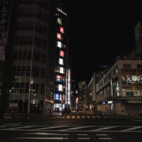 照明の付いた袖看板が立つ秋葉原の路地とビル群の写真