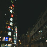 暗闇に浮かぶ秋葉原の袖看板と電飾看板の夜景の写真