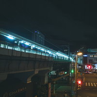 深夜の秋葉原駅ホームで点灯する赤信号と電車の写真