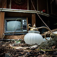 廃モーテルの地面に散乱する古いテレビと照明器具の写真