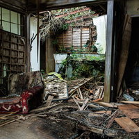 朽ちて崩壊した壁と瓦礫が散乱する廃墟の室内の写真