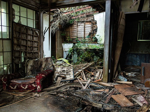 朽ちて崩壊した壁と瓦礫が散乱する廃墟の室内