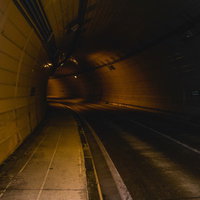 薄暗い照明のトンネル内部の道路の写真