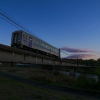 旭川のローカル線が夕暮れの橋を渡る電車と河川風景の写真