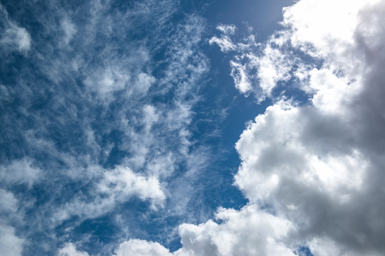 雲が浮かぶ昼の太陽と青い空