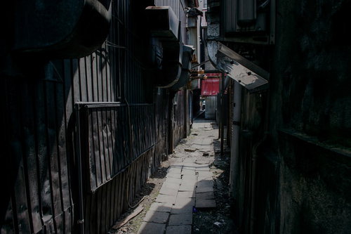 暗い照明と古い壁に囲まれた不気味な路地裏の風景