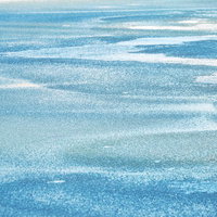 光を反射する細かな波紋の水面の写真