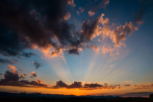 夕焼け空に広がる雲と放射状の光