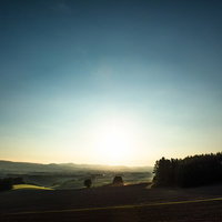 夕暮れ時の美瑛の田園風景と山並みの写真