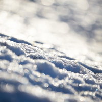 冬の雪面と反射する光の粒の写真