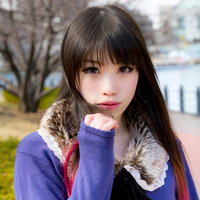 冬の街道でマフラーを巻いてこちらを見つめる女性の写真