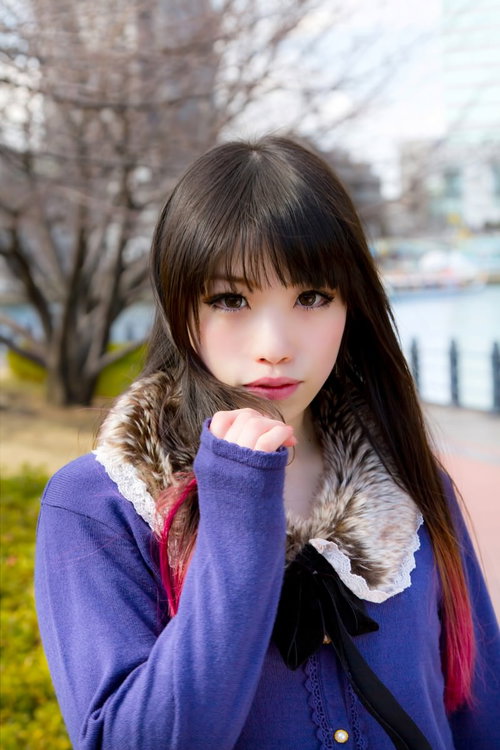 冬の街道でマフラーを巻いてこちらを見つめる女性