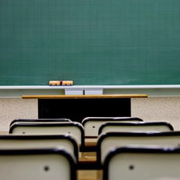 教卓に向かって机が並ぶ低い位置から撮影した教室の写真