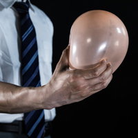 風船を鷲づかみする会社員の手、ビジネスシーンでの決定力を表現の写真