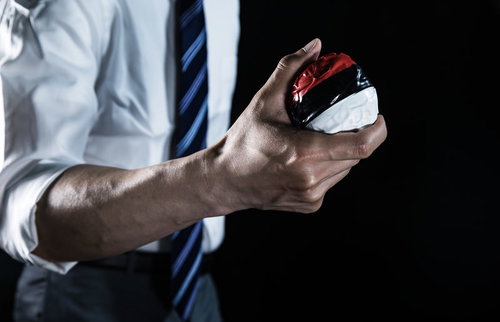 紅白ボールを握りしめるスーツ姿の会社員ゲーマー