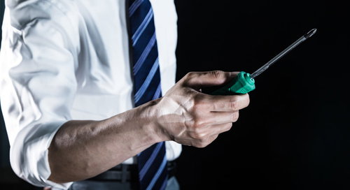 プラスドライバーを握る会社員の様子