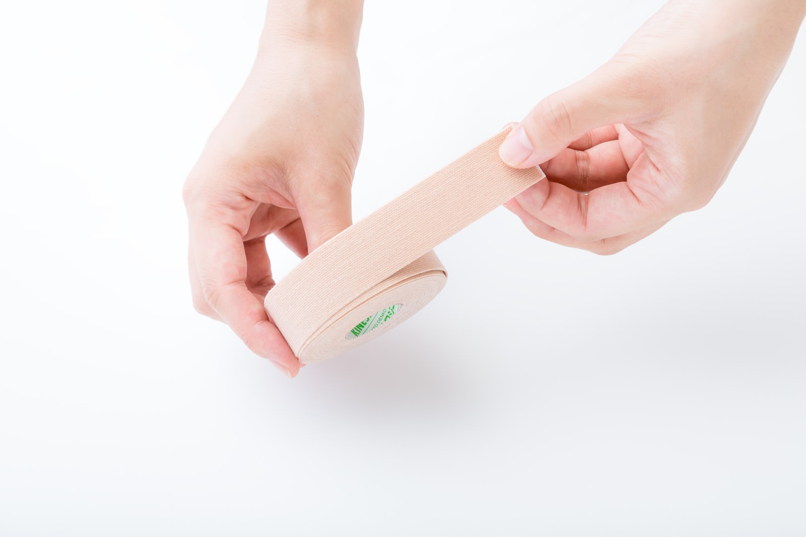 医療用キネシオテープを肌に貼る施術者の手元