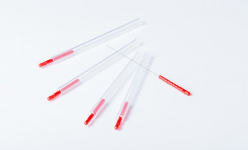 赤い鍼と透明な鍼管、複数サイズの鍼治療用医療器具