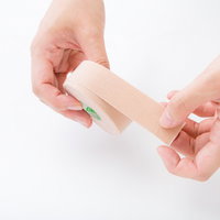 キネシオテープを両手で装着する整骨院の施術方法の写真