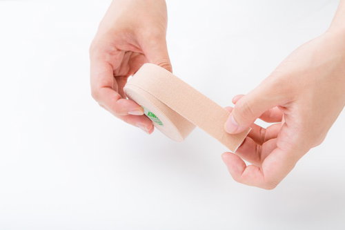 キネシオテープを両手で装着する整骨院の施術方法