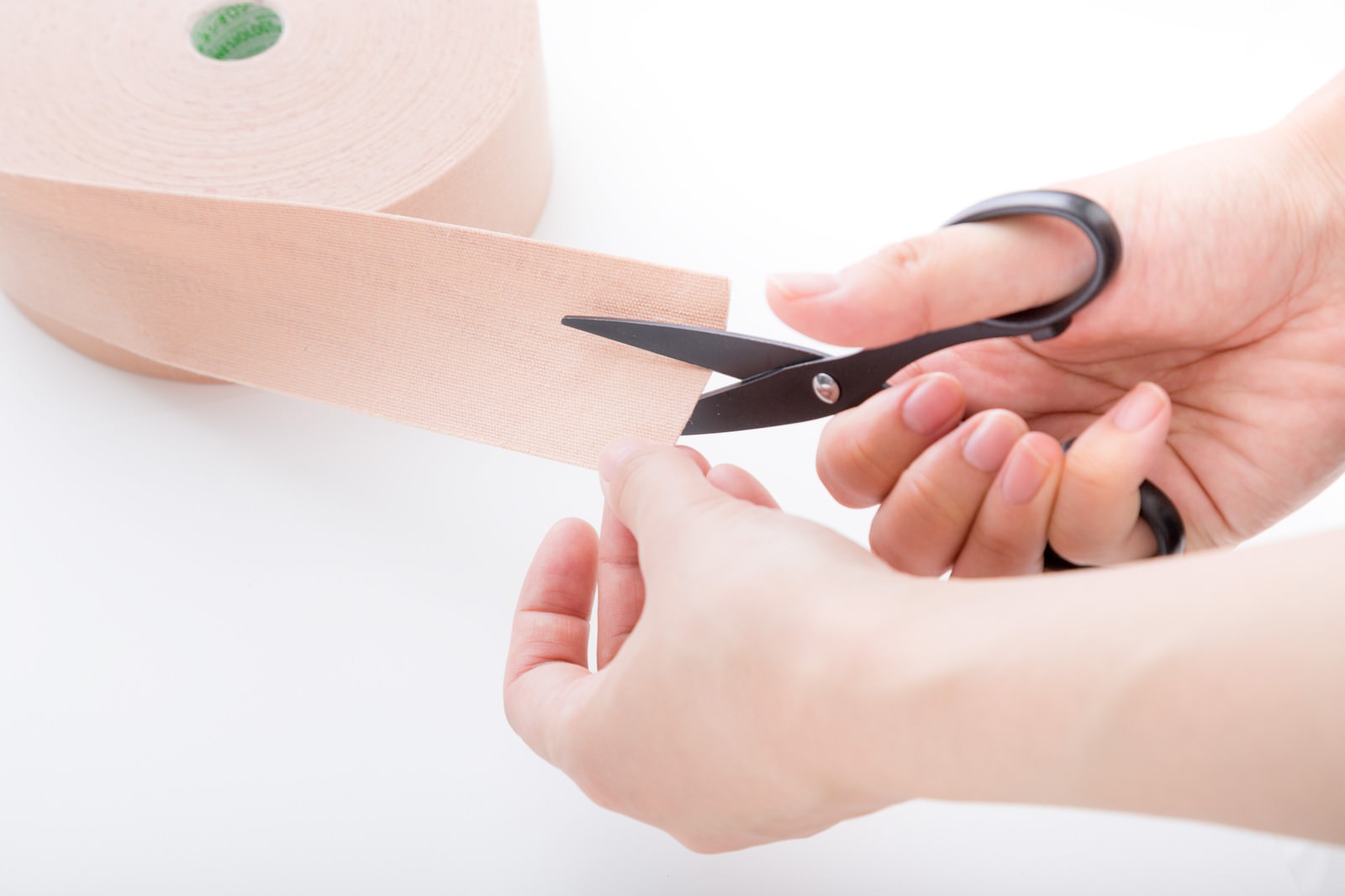 げんき堂整骨院でキネシオテープをハサミでカットしている手元の写真