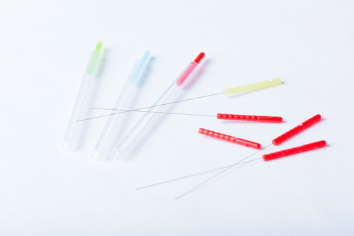 鍼灸専用の鍼で腕に施術する手元