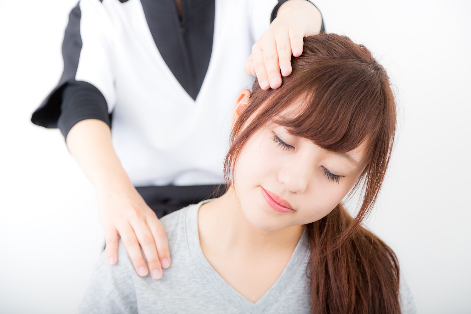 リラクゼーションサロンで施術者に首をマッサージされている女性［モデル：河村友歌］