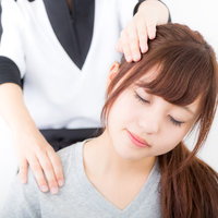 リラクゼーションサロンでの首と肩の施術を受ける女性の写真