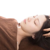 頭部のツボを指圧でもみほぐす、リラックス効果のあるヘッドマッサージ施術の写真