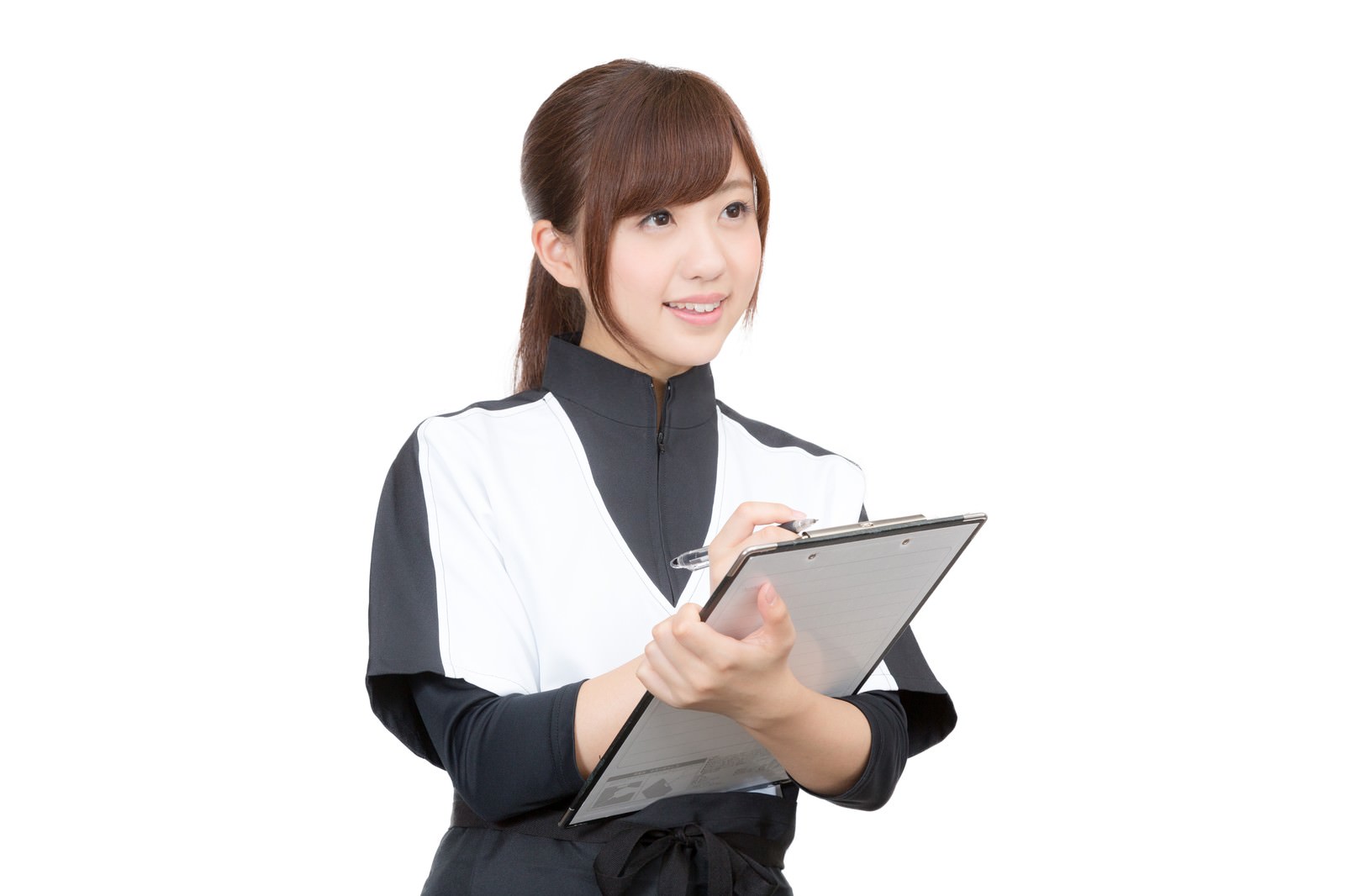 クリップボードを持って顧客に問診する黒と白のジャケット姿の女性スタッフ［モデル：河村友歌］