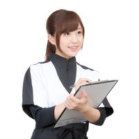 クリップボードを持ちながら問診を行う女性スタッフの写真