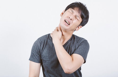 肩こりが酷くて首に手をあてて苦しむ男性の体調管理