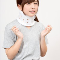 頚椎カラーを装着した首が痛い女性、首痛やむち打ちの治療の写真