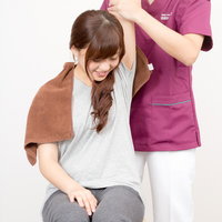 げんき堂整骨院での肩もみ施術を受ける女性の写真