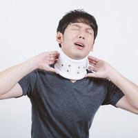 辛いむち打ちで頚椎カラーを装着する男性の治療の写真