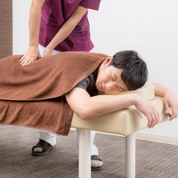 整骨院でマッサージを受けて全身の疲れを取る女性の写真