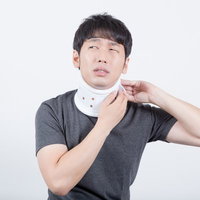 首の痛みでつらいむち打ち、ギブスで固定された男性の写真