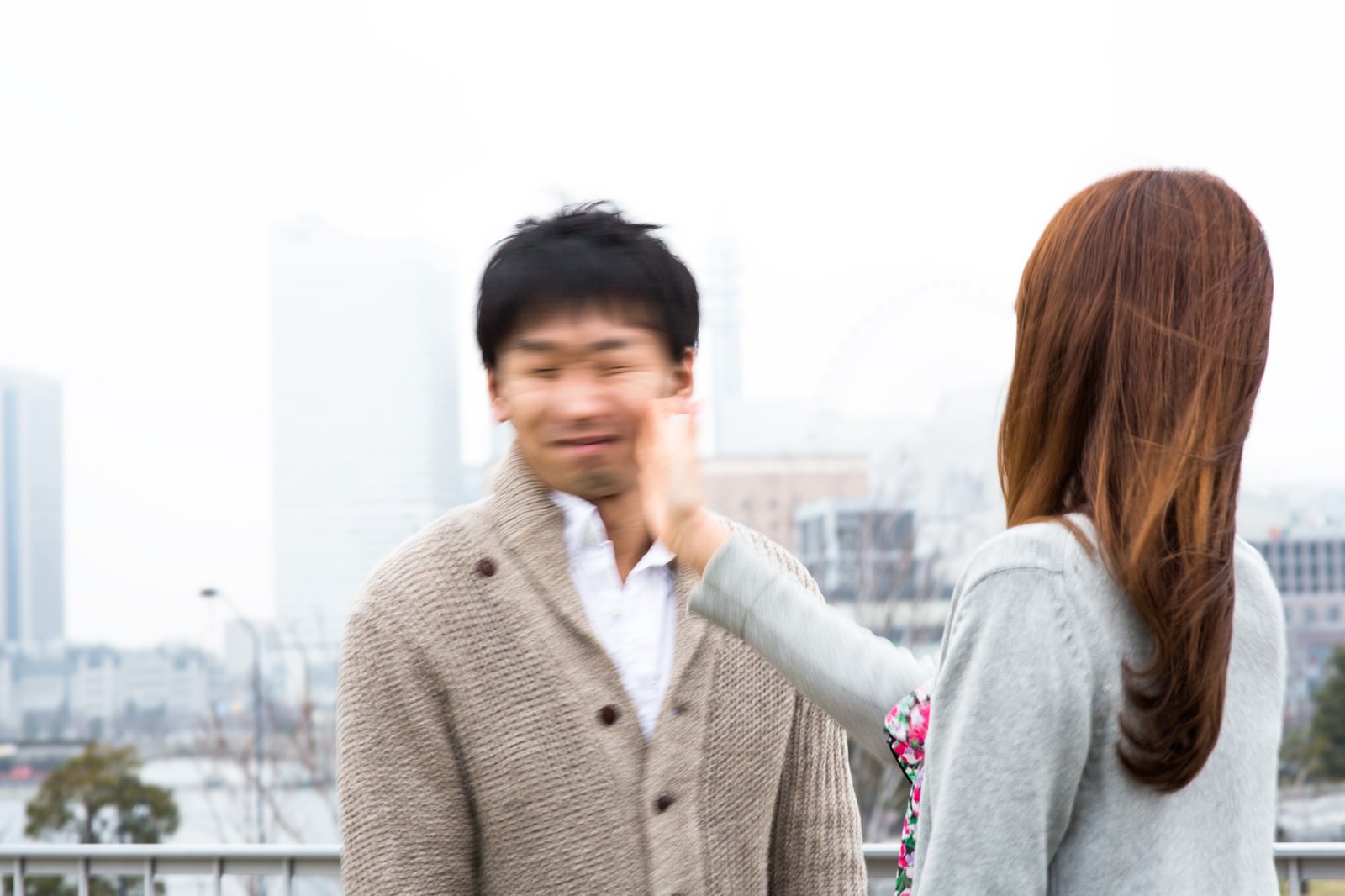 屋外で男性に平手打ちする女性［モデル：大川竜弥］