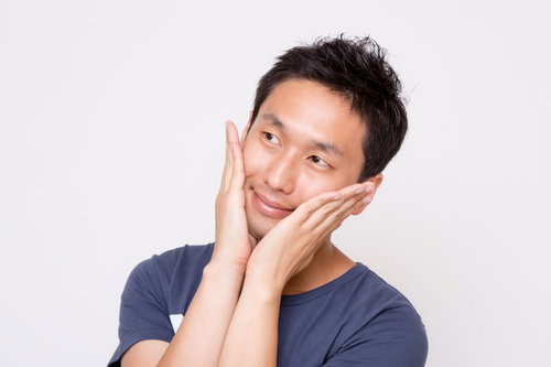 両手で頬を包んで上を見上げる男性