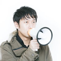 マイクで案内や告知をする男性の写真