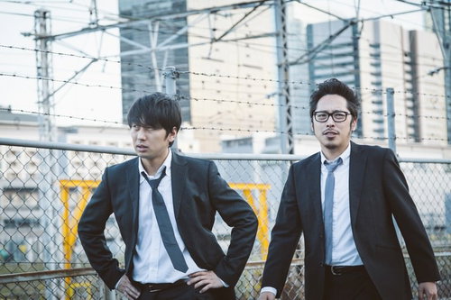 都市の高架下で立ち止まる帰社か直帰か悩む若手営業コンビ