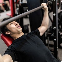 バーベルを握る位置がわからないトレーニング初心者の男性の写真