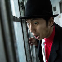 尾行相手に事務所がバレた迷探偵の驚く顔と身を隠す仕草の写真