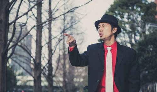 道案内をする強面のエージェント男性が指をさす